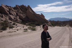 Kevin standing on a desert road, mountains in the background