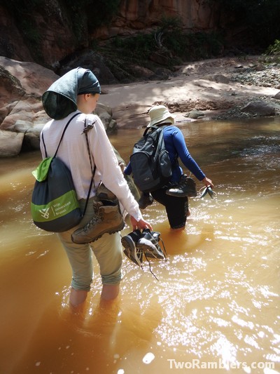 Two women crossing a muddy river