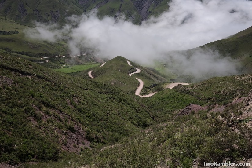 Winding road in green hills, clouds hanging low